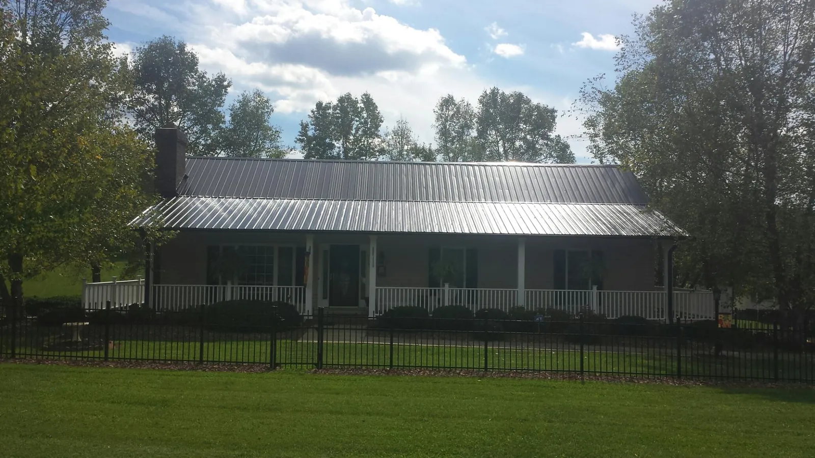 Gray metal roof on a brick ranch with a full width front porch — Gutter Guard Installation work by our crew in Anaheim