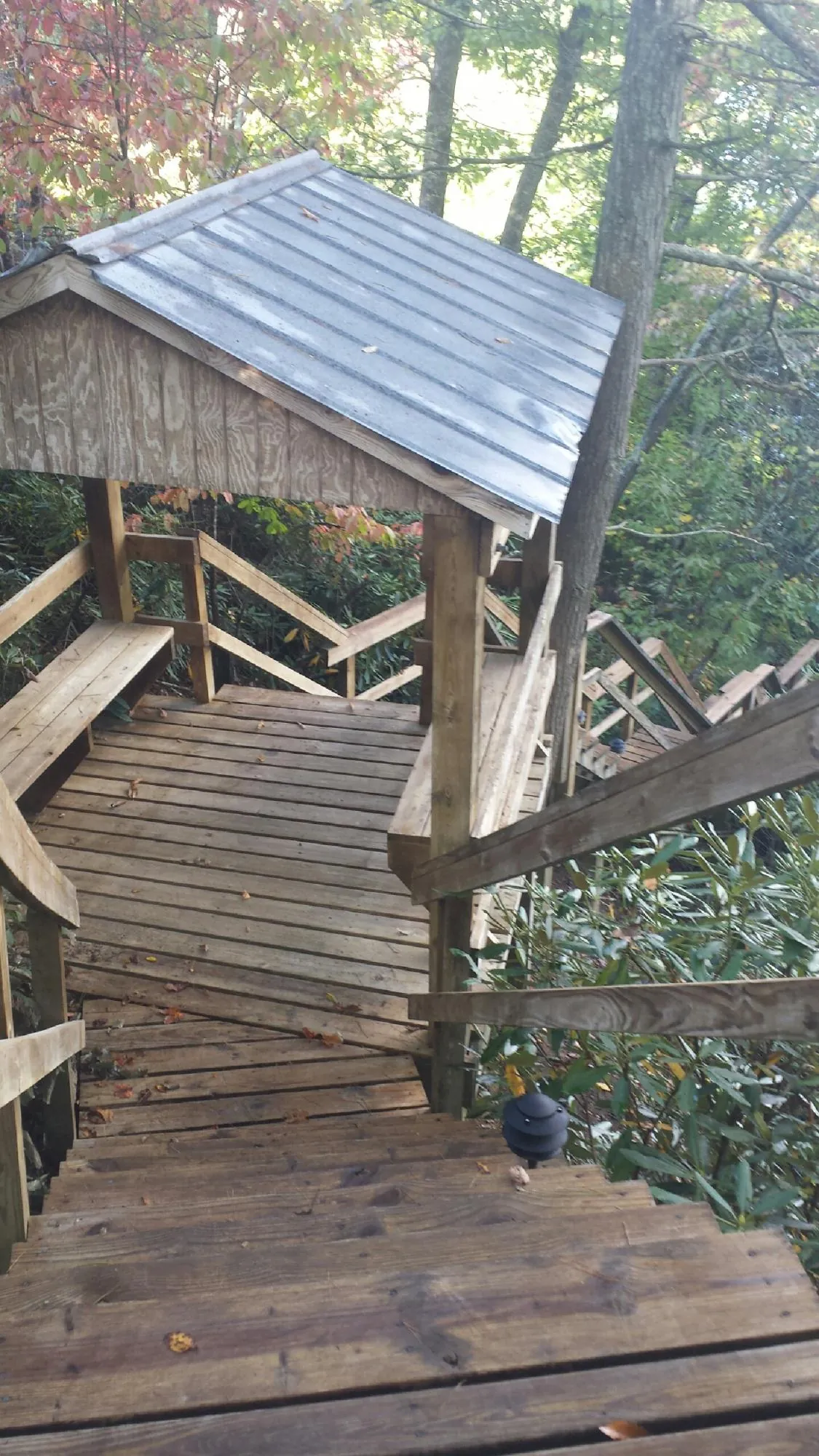 Metal roofed shelter over wooden steps on a wooded walkway — Skylight Repair & Installation work by our crew in Anaheim